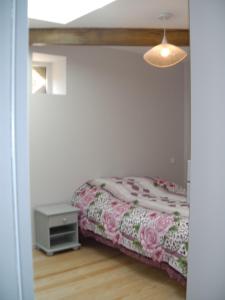 um quarto com uma cama, uma mesa e um candeeiro em Location meublée au milieu d'un écrin de verdure Aux vieux fours em Noaillac