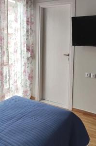 ein Schlafzimmer mit einem blauen Bett und einem Fenster in der Unterkunft Στούντιο Διπλα στην Ακρόπολη in Athen