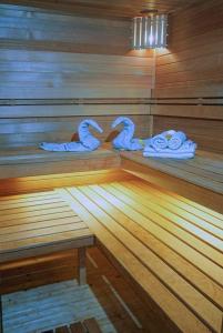 a sauna with three swan towels on a wooden floor at Velem Spirit Apartment in Velem