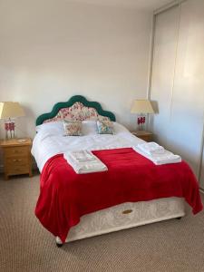 a bedroom with a large bed with a red blanket at The Smithfields, Newport in Newport