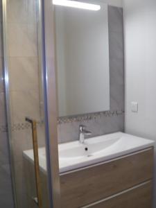 uma casa de banho com um lavatório e um espelho em Location meublée au milieu d'un écrin de verdure Aux vieux fours em Noaillac