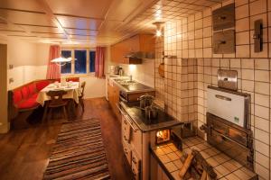 a kitchen with a stove and a dining room with a table at Alps Hoamat Ferienchalet in Mellau