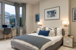 a bedroom with a bed and a desk and a window at Spring Mount Huge Luxury Full Apartment- Harrogate Centre-Two extremely comfy Kingsize Bedrooms-Fully equipped Modern Kitchen-Cosy living room with Huge TV in Harrogate