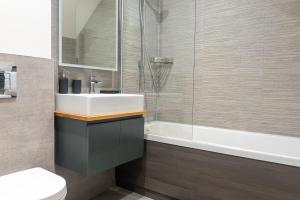 a bathroom with a sink and a bath tub at Spring Mount Huge Luxury Full Apartment- Harrogate Centre-Two extremely comfy Kingsize Bedrooms-Fully equipped Modern Kitchen-Cosy living room with Huge TV in Harrogate