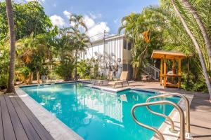 uma piscina num resort com palmeiras em Papa's Hideaway em Key West