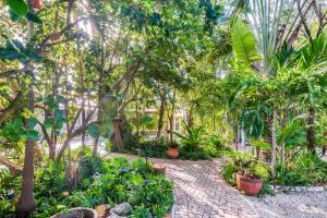 a garden with palm trees and a brick path at Papa's Hideaway in Key West