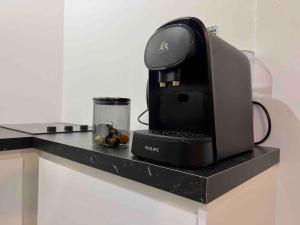 a coffee machine sitting on a counter with a cup at Appartement chaleureux proche RER/ CDG / Parc Expo in Sevran