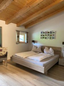 Cette chambre comprend un grand lit et un plafond en bois. dans l'établissement Hotel Sonnenlicht Maria Alm, à Maria Alm