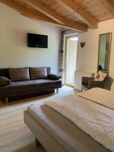 a living room with a bed and a couch at Hotel Sonnenlicht Maria Alm in Maria Alm am Steinernen Meer