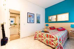 sypialnia z łóżkiem i niebieską ścianą w obiekcie Sevilla Central Suites Apartamentos Puerta Jerez w Sewilli