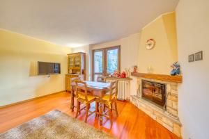 a kitchen with a table and a fireplace at Elegante appartamento-100mt dal centro-50mt dalla seggiovia-wifi-parcheggio gratuito in Sauze dʼOulx