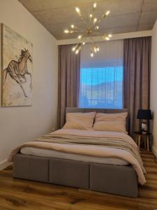 duże łóżko w sypialni z oknem w obiekcie Apartament Wyspiański w mieście Sanok