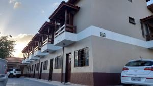 ein Gebäude mit davor geparkten Autos in der Unterkunft Casa aconchegante com ar condicionado para família em condomínio in Caraguatatuba