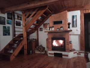 a living room with a fireplace and a staircase at Dom pod jabłonkami in Zarzecze