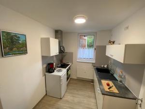 eine kleine Küche mit einem weißen Kühlschrank und einem Herd in der Unterkunft Schöne Ferienwohnung „Zum Glück“ in Eisenach