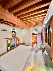 フェズにあるDar Bhijaの木製の天井、大きな白いベッドが備わるベッドルーム1室が備わります。