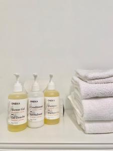 three bottles of sunscreen sitting on a shelf next to towels at Beatnik Hotel in Bromont