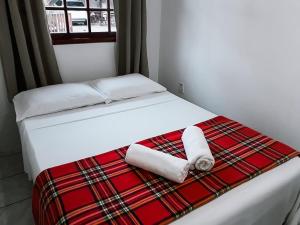 a bed with two rolled towels on top of it at Pousada Moçambique in Florianópolis
