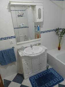 a bathroom with a sink and a mirror and a tub at Elegant Sea View Apartment in Nazaré +21 photos