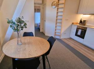 a kitchen and a table with a vase of flowers on it at Staying-Inn Enschede in Enschede