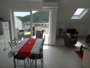 un soggiorno con tavolo, sedie e una grande finestra di Apartments Roko a Dubrovnik