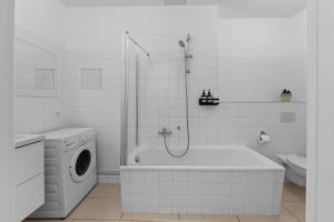 y baño blanco con bañera y lavadora. en Beautiful 80sqm Appartment in Berlin-Mitte en Berlín