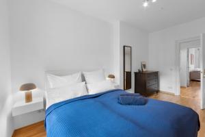 a white bedroom with a blue bed and a mirror at Beautiful 80sqm Appartment in Berlin-Mitte in Berlin