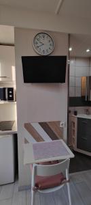 un reloj en la pared con una silla en la cocina en studio-centre-Thabor-balcon-1 personne en Rennes