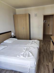 a bedroom with two beds with white sheets at Urlaub - Obzor Beach Resort A109 in Obzor