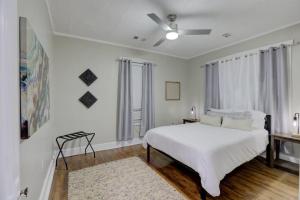 a white bedroom with a bed and a window at Cooper Young Bungalow with All the Essentials in Memphis