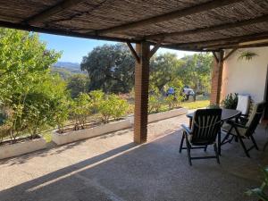 un patio con mesa y sillas bajo una pérgola en Alojamiento rural Rancho Valero en El Bosque