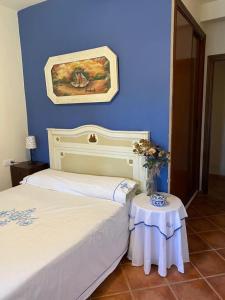 1 dormitorio con pared azul y 1 cama con mesa en Alojamiento rural Rancho Valero en El Bosque
