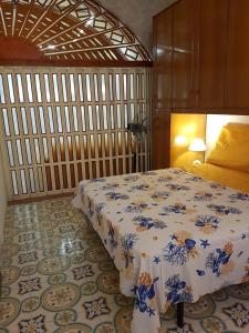 1 dormitorio con 1 cama con manta azul y blanca en Dal corso al mare, en Spadafora