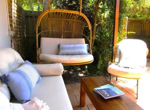 a patio with two chairs and a couch and a table at Byron Marvell in Byron Bay