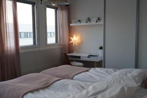 Schlafzimmer mit einem Bett, einem Schreibtisch und Fenstern in der Unterkunft Cozy and Bright 2-Bedroom Apartment Washer and Dryer, King Size Bed in Rovaniemi