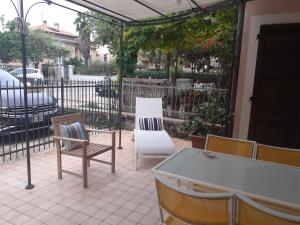 a patio with a table and chairs and a fence at Bouganville House in Senigallia