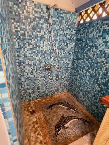 a shower with a mosaic floor in a bathroom at Fare Ihilei in Fare