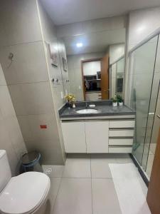 een badkamer met een toilet, een wastafel en een spiegel bij Eco Resort Praia dos Carneiros - Flat 116CM, apartamento completo ao lado da igrejinha in Praia dos Carneiros