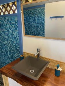 La salle de bains est pourvue d'un lavabo et d'un miroir. dans l'établissement Fare Ihilei, à Fare