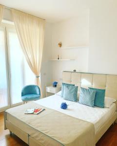 um quarto com uma cama grande e uma cadeira azul em B&B Home Flowers Milano em Milão