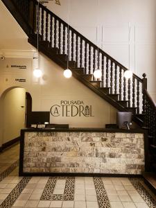 a lobby with a staircase and a sign on the wall at Pousada Catedral in Petrópolis