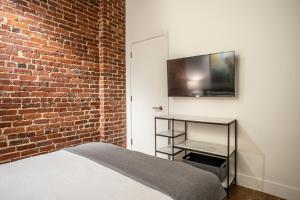 a bedroom with a bed and a brick wall at Elevation Lofts Hotel in Asheville