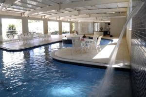 uma piscina com mesas e cadeiras num edifício em Hotel Premium Campinas em Campinas