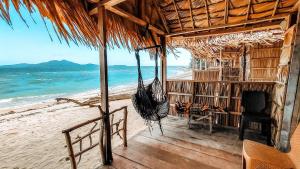 Selpele的住宿－Kamar Raja GuestHouse，海滩上带吊床的海滨别墅