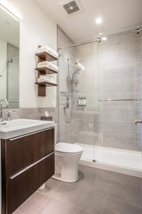 a bathroom with a shower and a toilet and a sink at Elevation Lofts Hotel in Asheville