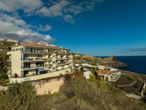 a building on a cliff next to the ocean at Reis Magos Apartment by HR Madeira in Caniço