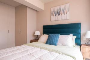 une chambre avec un grand lit et une tête de lit bleue dans l'établissement Elegant&Modern Apt in San Isidro, à Lima