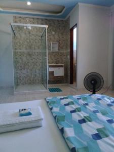 ein Bad mit Dusche und ein Bett in einem Zimmer in der Unterkunft Hospedagem Pousada Fantasia Paraty in Paraty