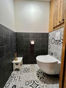 a bathroom with a toilet and a tiled floor at L’Appart de Céline **** haut standing hypercentre in Gérardmer