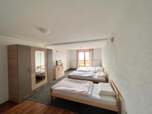 Zimmer mit 3 Betten und einem Spiegel in der Unterkunft Planinska kuća Vlašić in Vlasic